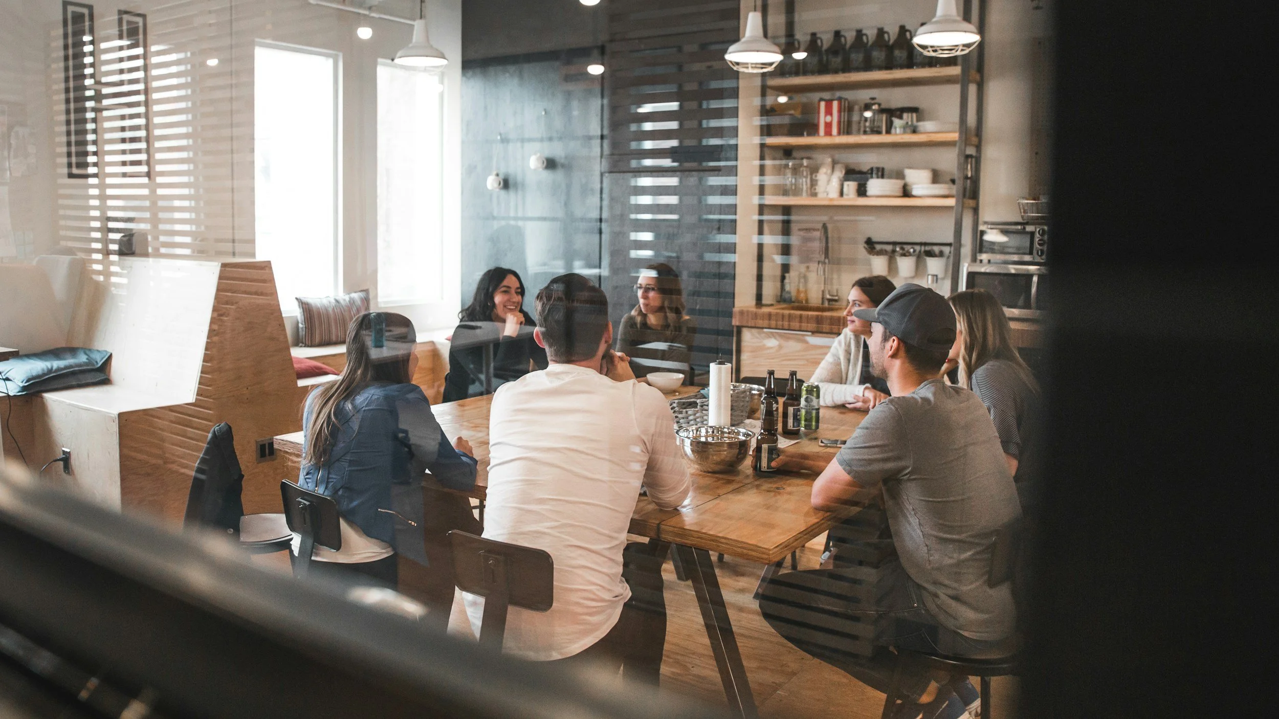 A team meeting around a wooden table in a bright office.