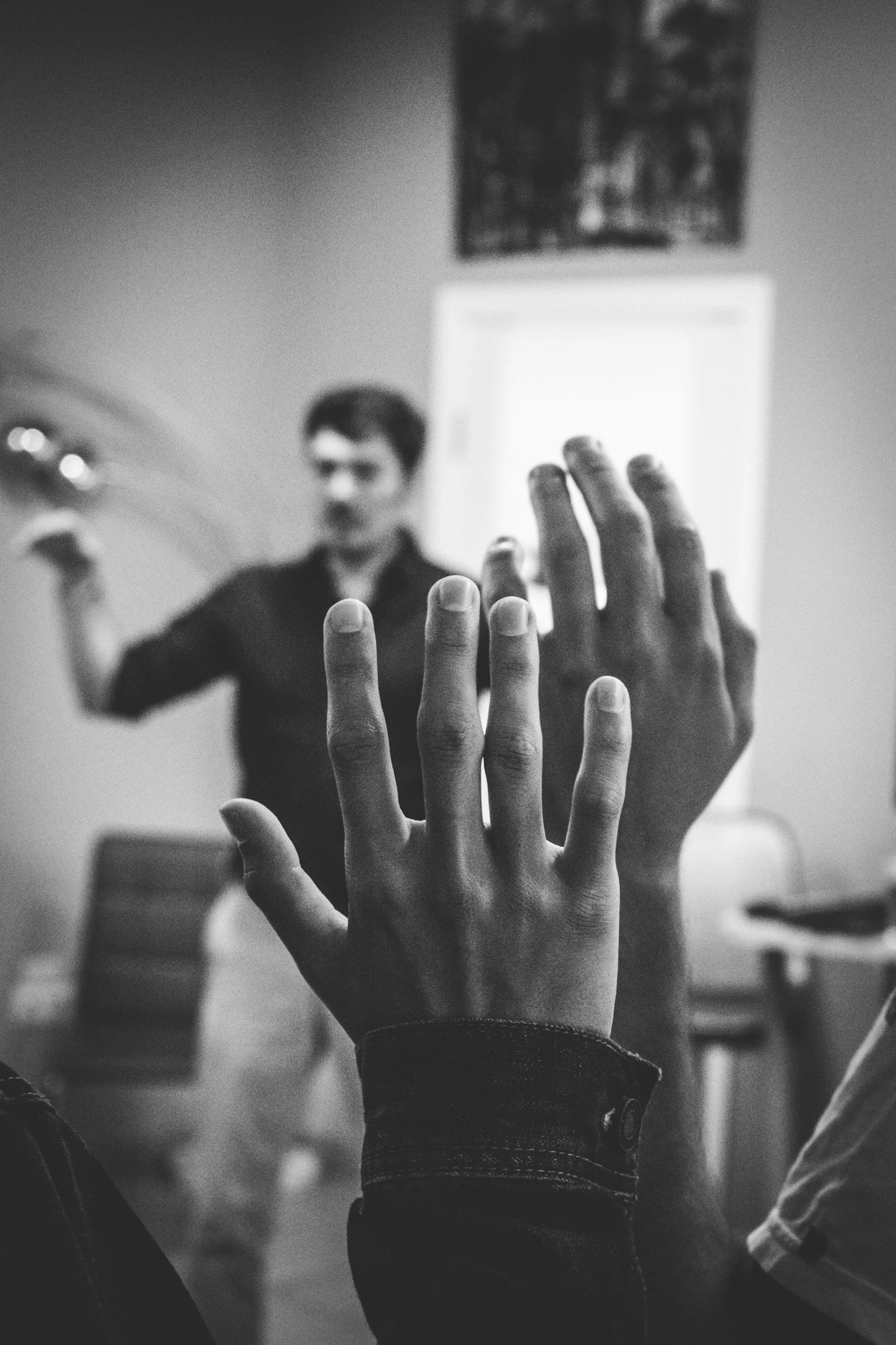 Hands raised in a workshop or meeting.